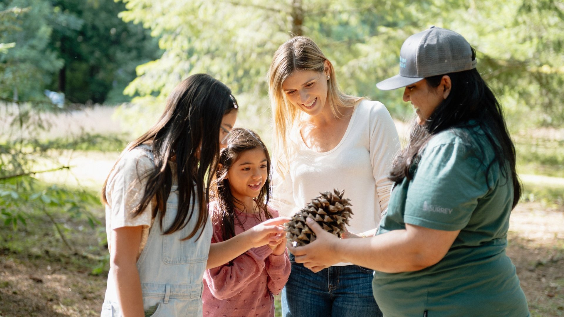 A family receiving a guided tour and viewing a large pinecone at the Surrey Nature Centre Ian Harland DSC 1332