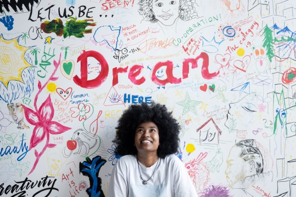 Art Curator standing in front of decorative whiteboard at Black Arts Museum
